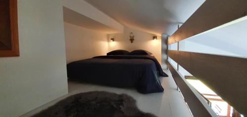 1 dormitorio con 1 cama en una habitación pequeña en Les Lucioles, en Saint-Jean-de-Sixt
