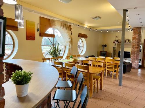 a dining room with wooden tables and chairs at Piejūras Nams in Ķesterciems