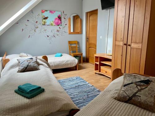 a bedroom with two beds and a table and a desk at Piejūras Nams in Ķesterciems