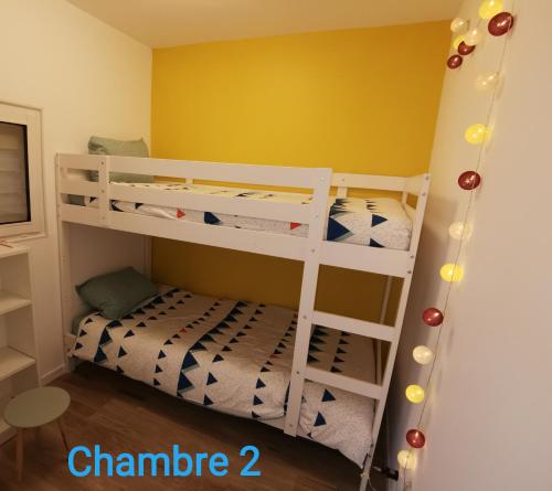 two bunk beds in a room with a yellow wall at Le Valadin in Valady