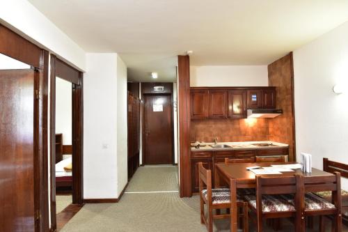 a kitchen with a table and a dining room at Apartments JAT Kopaonik in Kopaonik