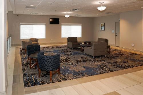 a waiting room with chairs and a table and a rug at Holiday Inn Express & Suites - Aurora Medical Campus by IHG in Aurora