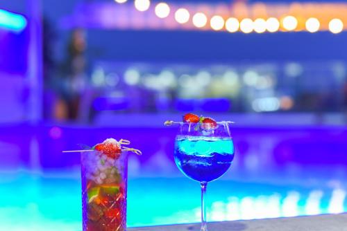 two cocktails sitting on a table in a bar at Denise Beach Hotel in Laganas