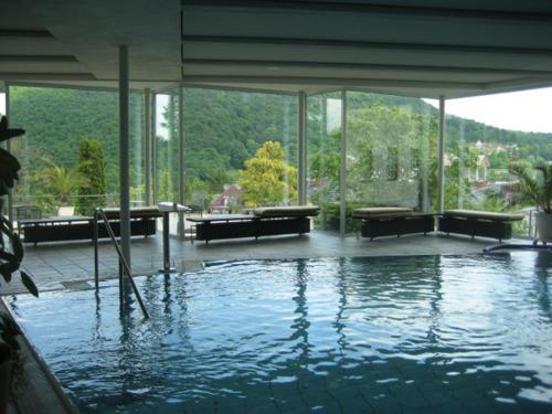 een groot zwembad met water in een gebouw met ramen bij Hotel Anna in Badenweiler