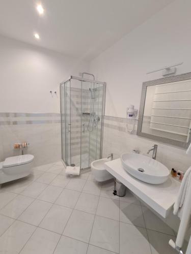 uma casa de banho branca com 2 lavatórios e um chuveiro em Baia del Sole Vasto em Vasto