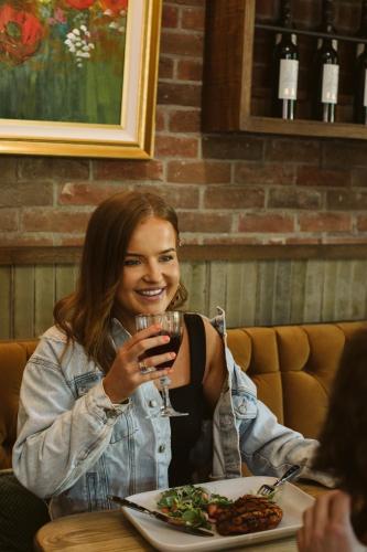 a woman sitting at a table with a glass of wine at The Rabbit Hotel & Retreat in Templepatrick