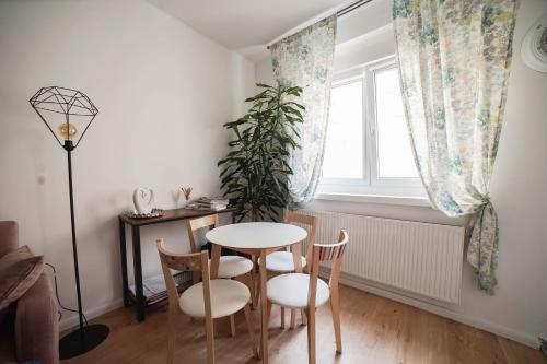 Un comedor con mesa y sillas y una ventana. en BELLA Rosa, en Opole