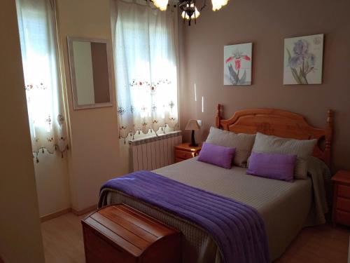 a bedroom with a large bed with purple pillows at La Pérgola Internet Fibra Garage Calefacción TV in Bronchales