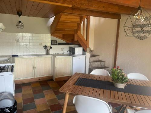 a kitchen with a wooden table and white appliances at Superbe gîte Laugy dans les montagnes d'Ambert in Valcivières