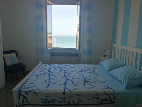 a bedroom with a bed and a window with the ocean at Casa Anna (Sturla sul mare, Ospedale Gaslini) in Genova