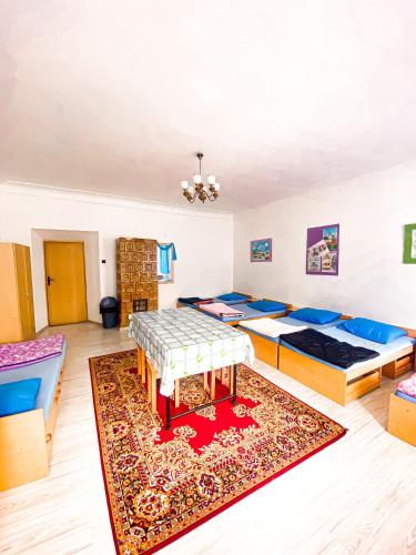 a room with three beds and a rug at Schronisko Młodzieżowe PTSM "Alko" in Rzeszów