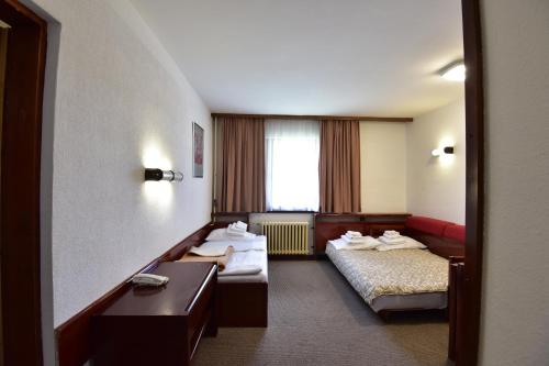 a hotel room with two beds and a window at Apartments JAT Kopaonik in Kopaonik