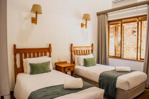 a room with two beds and a window at Kruger Park Lodge Unit 245 in Hazyview