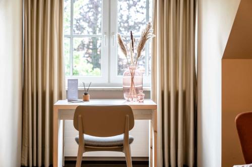 stół z krzesłem przed oknem w obiekcie Feldmochinger Hof w Monachium