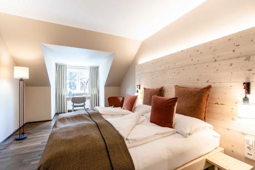 1 dormitorio con 1 cama grande y pared de madera en Feldmochinger Hof en Múnich