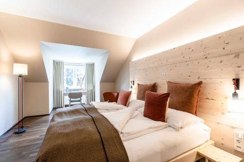 een slaapkamer met een groot bed en een houten muur bij Feldmochinger Hof in München