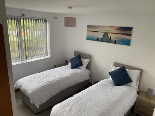 a bedroom with two beds and a picture on the wall at Toothbrush Apartments - Nr Train Station in Ipswich