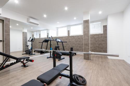 a gym with several treadmills and cardio machines at Horizon Hotel Badesi in Badesi