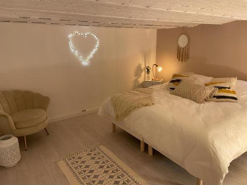 a bedroom with a bed and a heart sign on the wall at Villa avec maxi Jacuzzi aux Portes de Paris in Arcueil