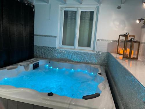 eine Whirlpool-Badewanne mit blauem Wasser im Badezimmer in der Unterkunft Villa avec maxi Jacuzzi aux Portes de Paris in Arcueil