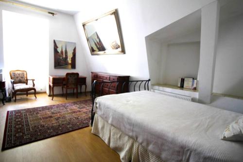 1 dormitorio con cama, escritorio y espejo en Orchidea Apartment, en Lublin