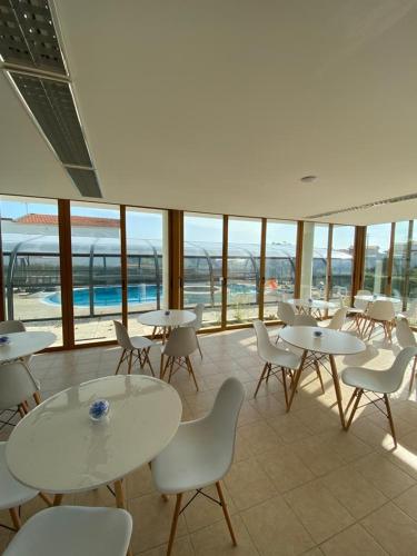 a dining room with tables and chairs and windows at Buarcos Luxury Guest house in Figueira da Foz
