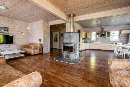 a living room with a fireplace and a couch and chairs at Эко-клуб Голицыно in Mikhaylovka