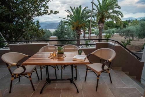 a wooden table and chairs on a patio at KRISSAIA SEASIDE SUITES in Galaxidhion
