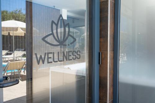 a glass door with a wellness sign on it at Horizon Hotel Badesi in Badesi