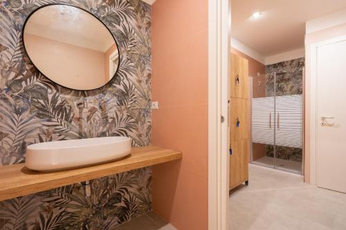 a bathroom with a sink and a mirror on a wall at Horizon Hotel Badesi in Badesi