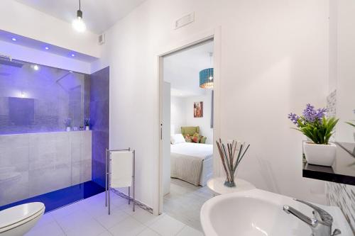 a bathroom with a sink and a toilet and a bedroom at siciliacasevacanze - Marina Domus Rooms in Marina di Ragusa