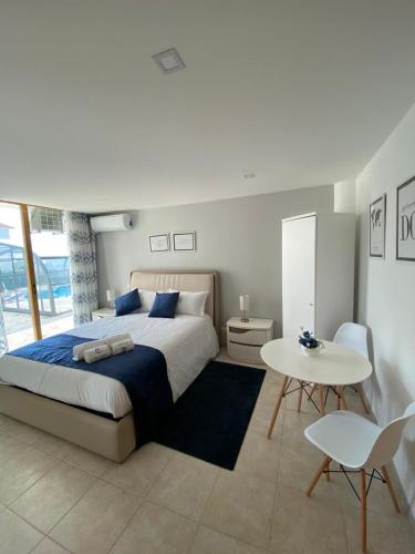 a bedroom with a large bed and a table at Buarcos Luxury Guest house in Figueira da Foz