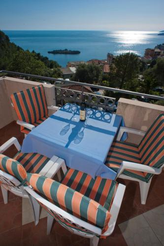 a table and chairs on a balcony with the ocean at Apartments Marina in Sveti Stefan