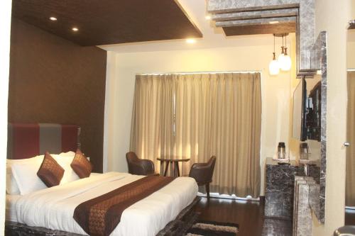 a hotel room with a bed and a table at S S INTERNATIONAL in Dalhousie