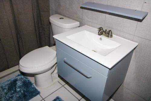 a bathroom with a white sink and a toilet at Mavs Boutique At Ponce in Ponce