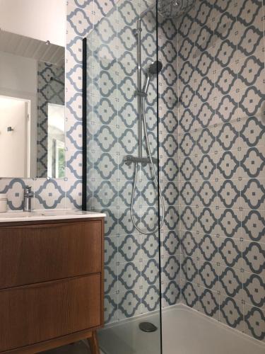 La salle de bains est pourvue d'une douche avec du carrelage bleu et blanc. dans l'établissement Jardin des Pérelles, à Varengeville-sur-Mer