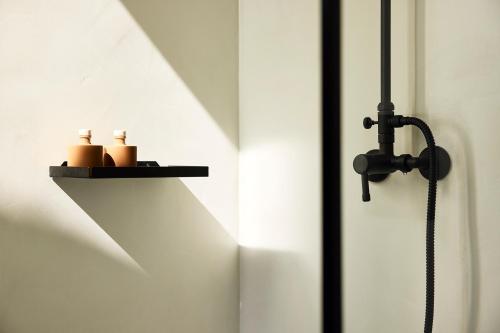 a shelf with two candles on a wall at Villa Costa Mare Milos - Delmar Collection in Pollonia