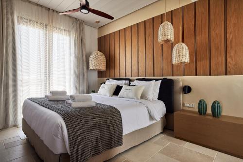 a bedroom with a large bed with towels on it at Villa Costa Mare Milos - Delmar Collection in Pollonia