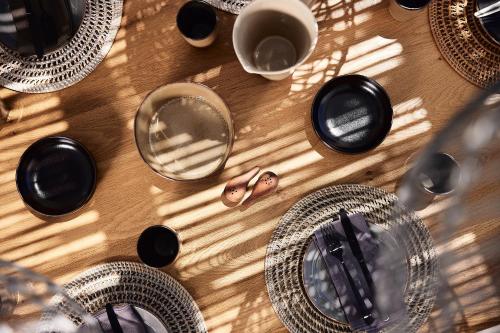 a table with plates and glasses on top of it at Villa Costa Mare Milos - Delmar Collection in Pollonia