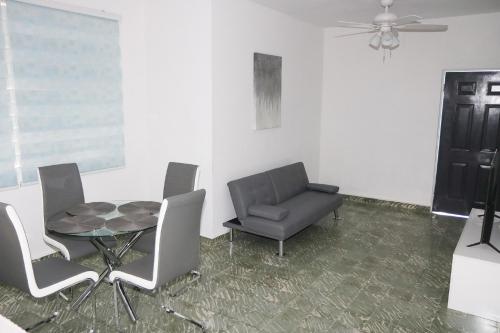a dining room with a table and chairs and a fan at Mavs Boutique At Ponce in Ponce