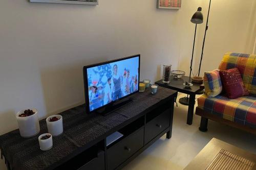 uma sala de estar com uma televisão de ecrã plano sobre uma mesa em Casa del Sole em Tollo