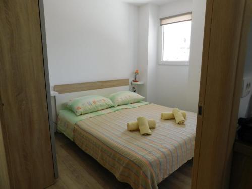 1 dormitorio con 1 cama con 2 almohadas amarillas en Studio Apartment Marinella, en Cres