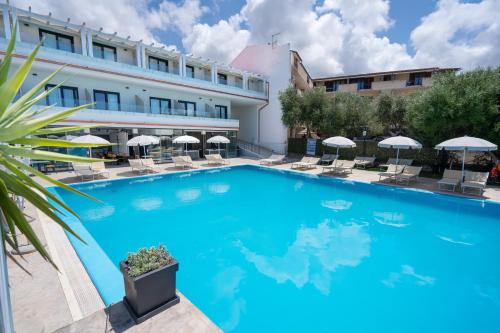 a large swimming pool in front of a hotel at Horizon Hotel Badesi in Badesi