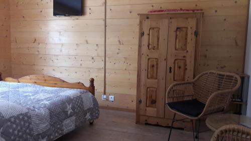 ein Schlafzimmer mit einem Bett und einer Holzwand in der Unterkunft Studio Le Plan Clou in Arbaz