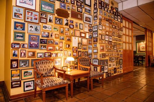 a wall with a table and two chairs and pictures at BON Hotel Bloemfontein Central in Bloemfontein
