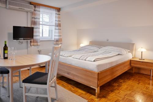 ein Schlafzimmer mit einem Bett und einem Tisch sowie ein Esszimmer in der Unterkunft Ferien- & Kürbishof Majczan in Bad Radkersburg
