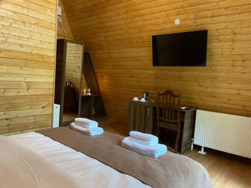a bedroom with a bed and a flat screen tv at Royal Palace Hotel, Lagodekhi in Lagodekhi