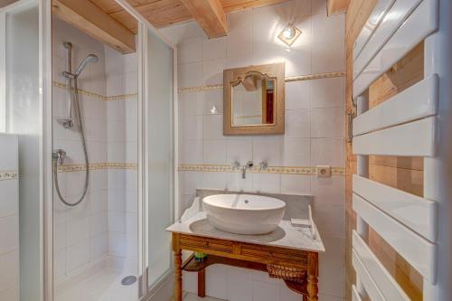 y baño con lavabo y ducha. en Chalet Cœur de Marie avec sauna et jacuzzi - Val d'Arly, en Flumet