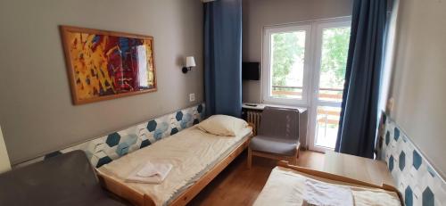 ポズナンにあるMotel Strzeszynekのベッドと窓が備わる小さな客室です。