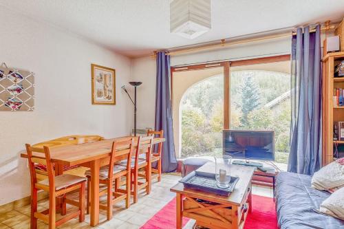 - un salon avec une table à manger et un canapé dans l'établissement Apartment Near The Slopes La Salle Des Alpes, à La Salle Les Alpes